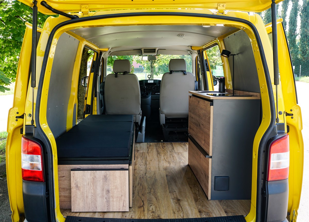 Mobile cucina con tavolo ribaltabile aperto, lavello nero e lampada