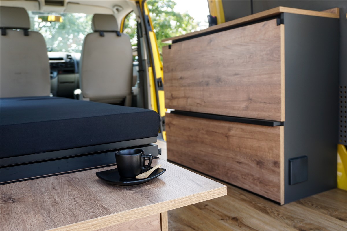 Volkswagen T5 giallo con portellone aperto: seduta in modalità giorno e blocco cucina
